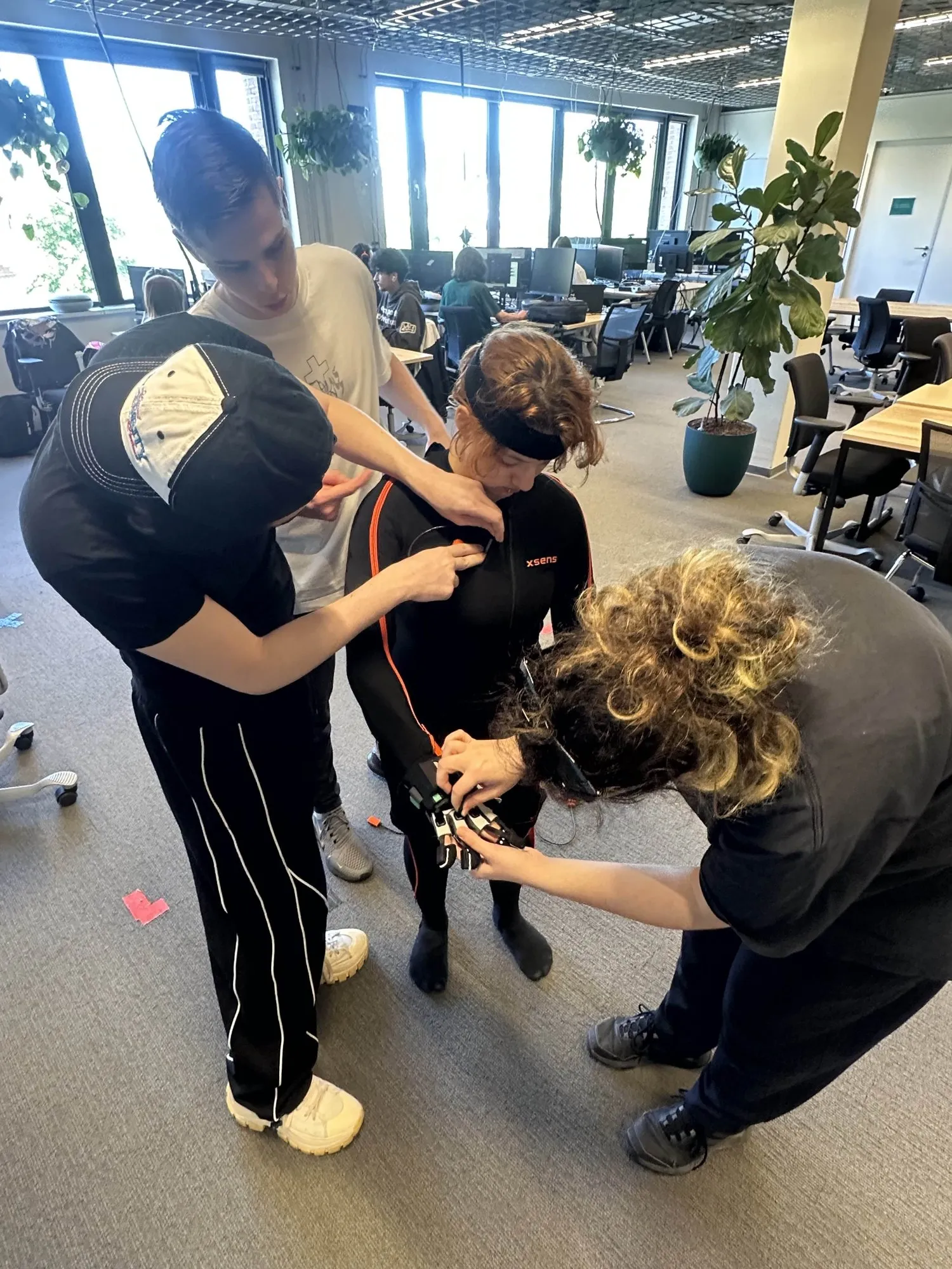 Team members fitting an Xsens motion capture suit on a dancer
